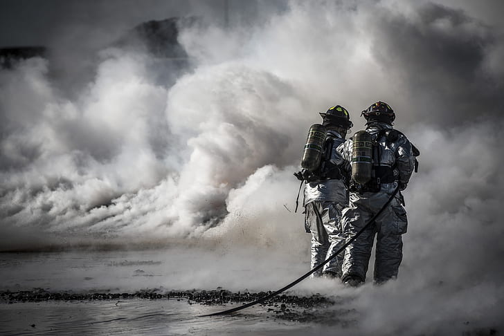 A firefighter silhouetted against smoke